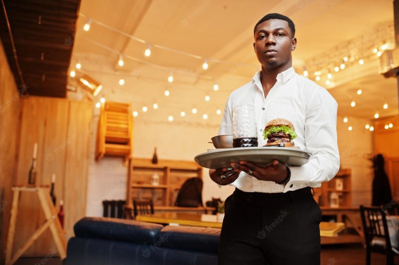 Young african american waiter man hold tray with burger at restaurant Free Photo Young african american waiter man hold tray with burger at restaurant Free Photo