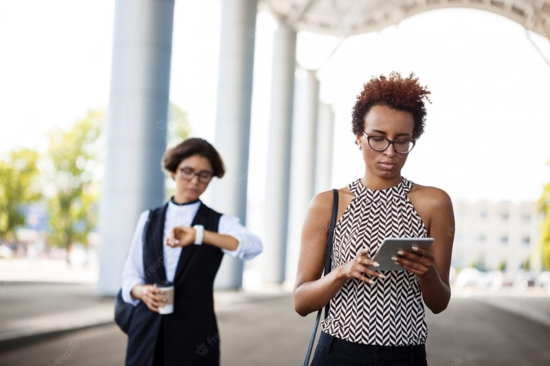 Young successful African businesswoman looking at tablet over business centre. Free Photo