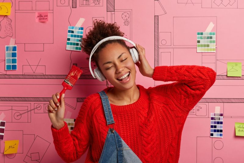 Young woman stands next to house design sketch ready for renovation Free Photo