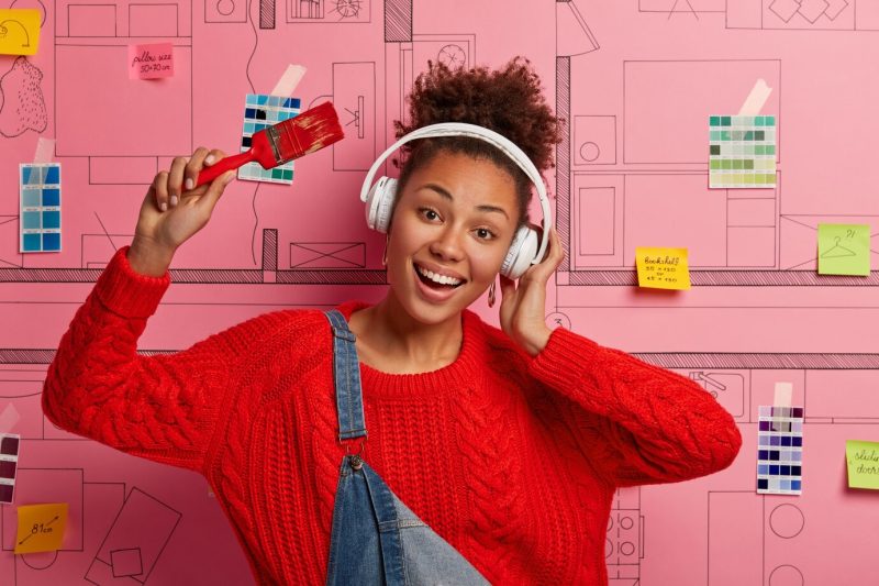 Young woman stands next to house design sketch ready for renovation Free Photo