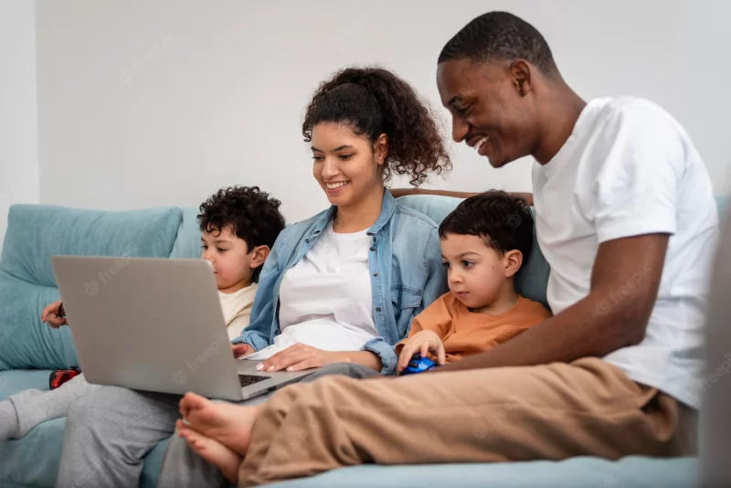 Happy black family watching a film on laptop Free Photo