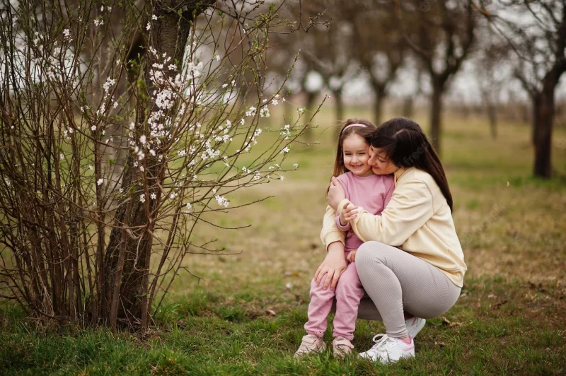 Mother hug her baby girl daughter in spring garden Free Photo