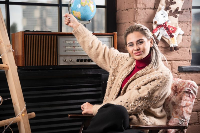 Portrait of beautiful lady holding a world globe up Free Photo