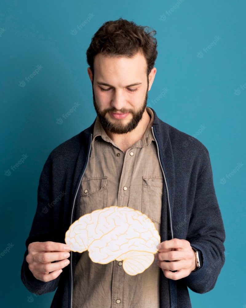 Portrait of man holding paper brain Free Photo
