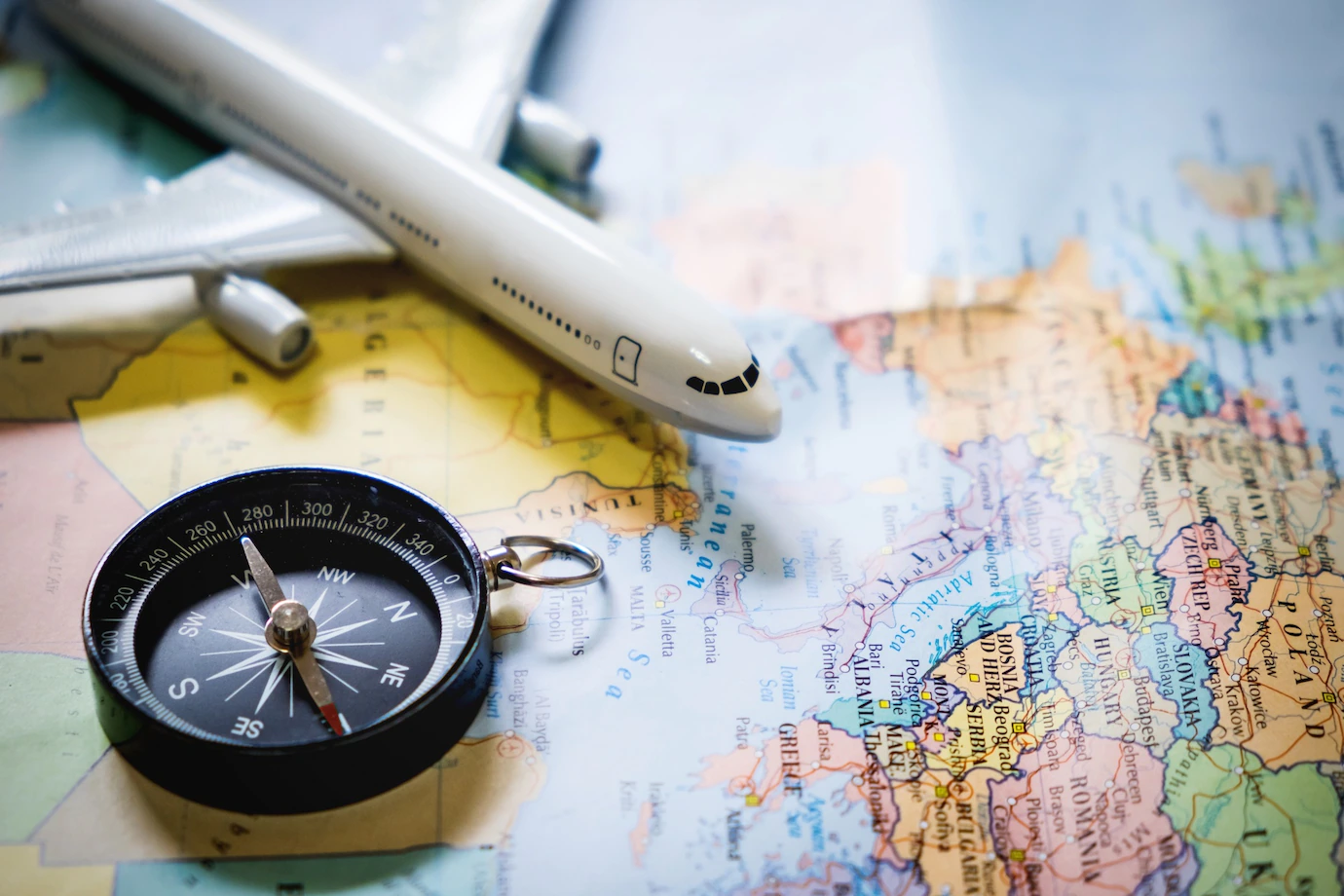 Selective Focus Miniature Tourist Compass Map With Plastic Toy Airplane Abstract Background Travel Concept 1423 180