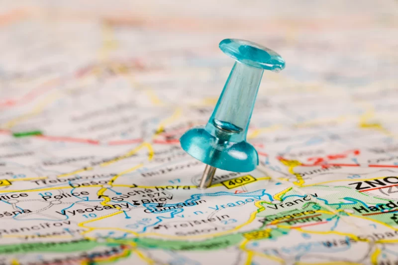 Turquoise colored pushpin tucked in world map Free Photo