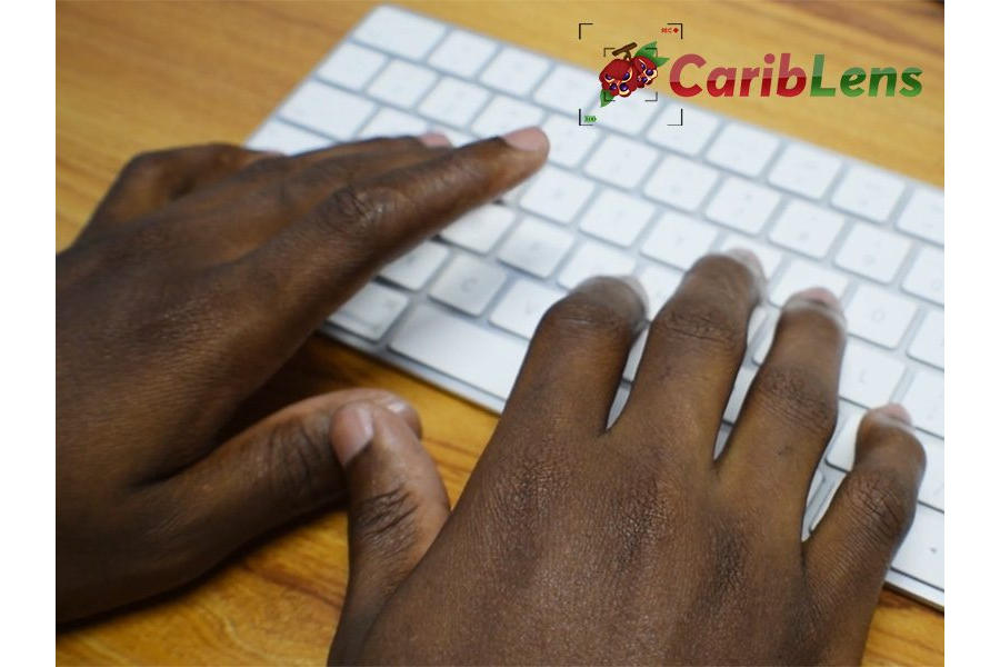 Black hands typing on a white keyboard