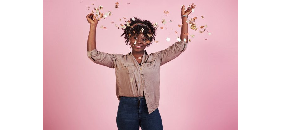 Throwing the confetti in the air. African black woman with on pink background behind Free Photo